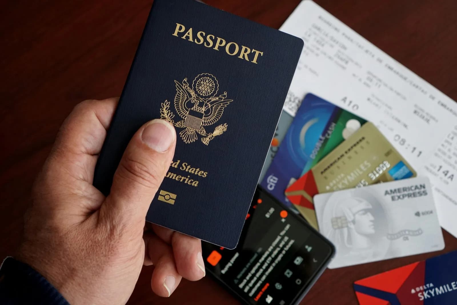 Passport and travel essentials arranged on a surface for trip planning