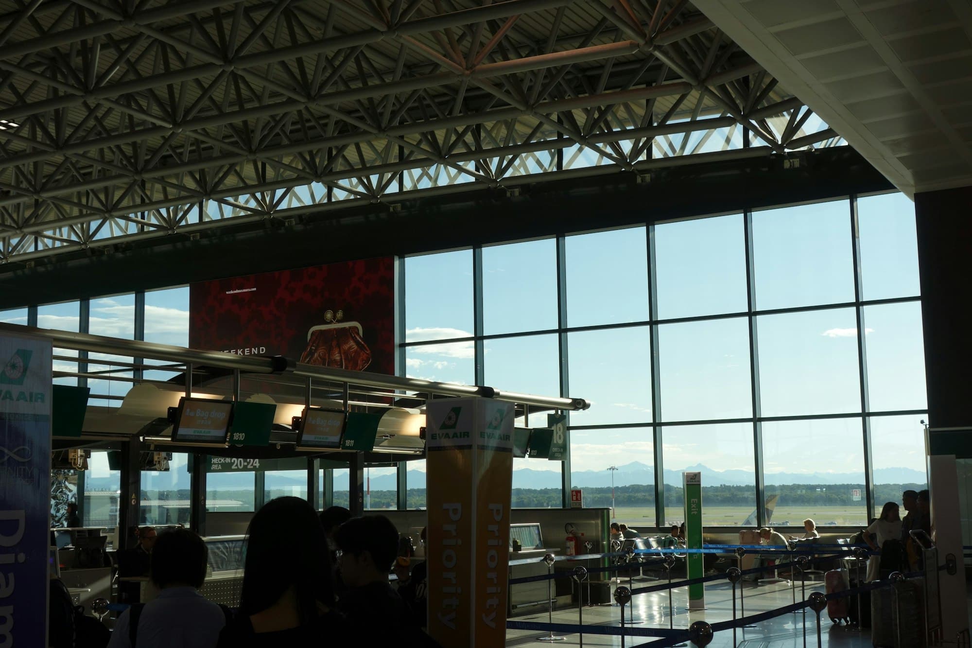 A large airport terminal stretches past check-in counters under a bright vaulted ceiling.